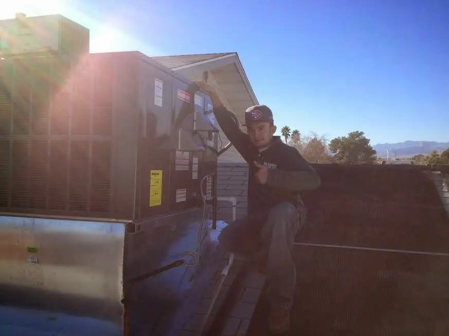 HVAC technician performing AC Tune-Up on a rooftop unit in League City